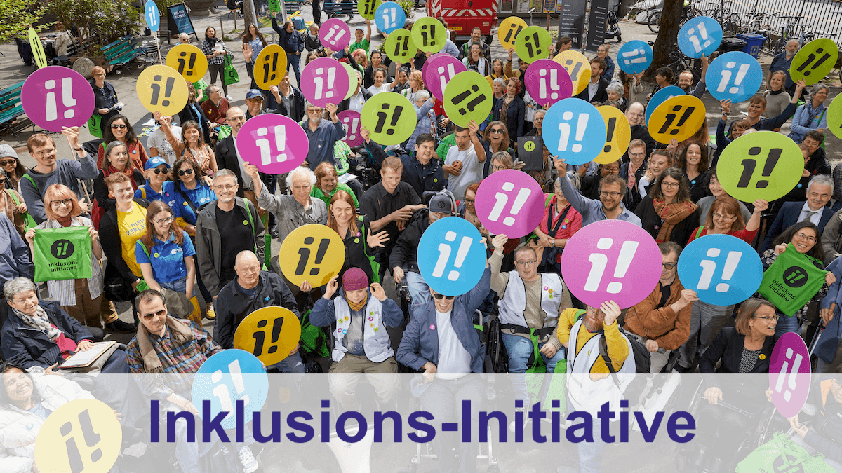 Unten: Schriftzug "Inkluions-Initiative". Darüber ein Foto mit Personen mit verschiedenen Behinderungen halten Schilder mit einem i und einem Ausrufezeichen hoch, das Logo der Inklusions-Initiative.