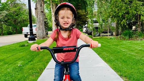 Fahrradfahrendes Kind auf Gehsteig