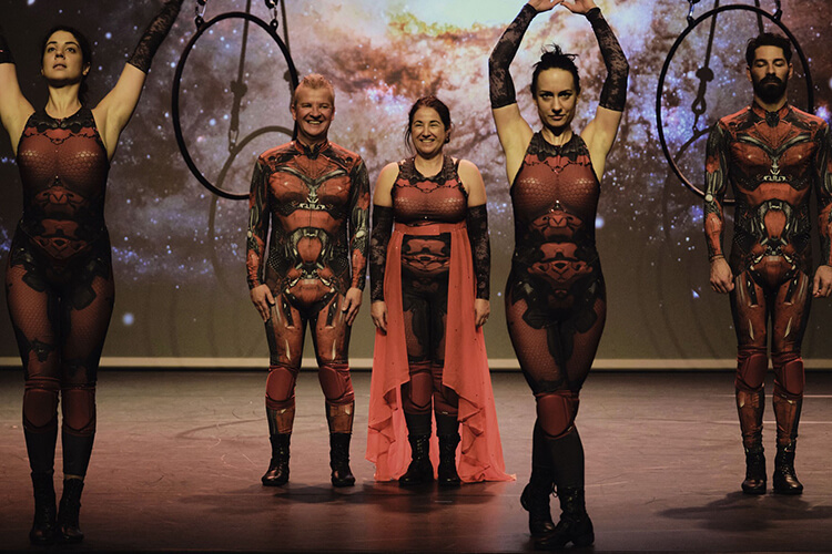 Tänzer in futuristischer rot/schwarzer Kleidung auf einer Bühne