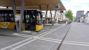 Postauto in einem Busbahnhof mit Leitliniensystem