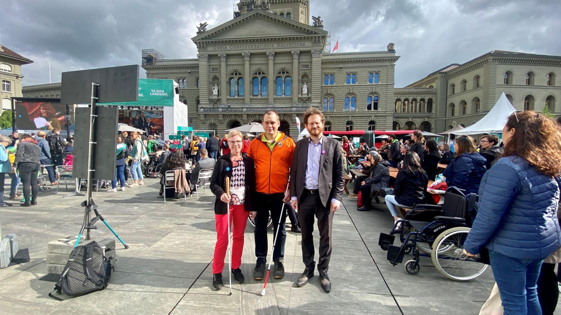 Die drei Nationalratskandidierenden mit Seheinschränkungen Marianne Plüss (Bern), Sébastien Piguet (Waadt) und Cyril Mizrahi (Genf) stehen gemeinsam vor dem Bundeshaus.